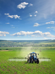 Farming tractor plowing and spraying