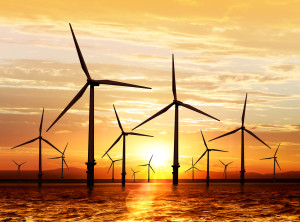 Silhouette of wind turbine generating electricity on sunset