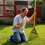 man having a heart attack chest pains while doing yard work